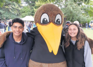 Kandoo mascot with arms around two students