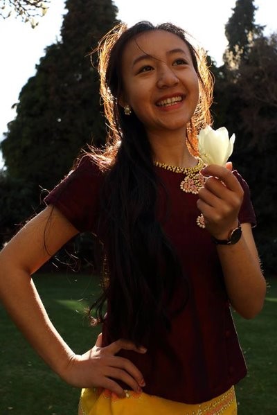 Christine smiling and holding a flower