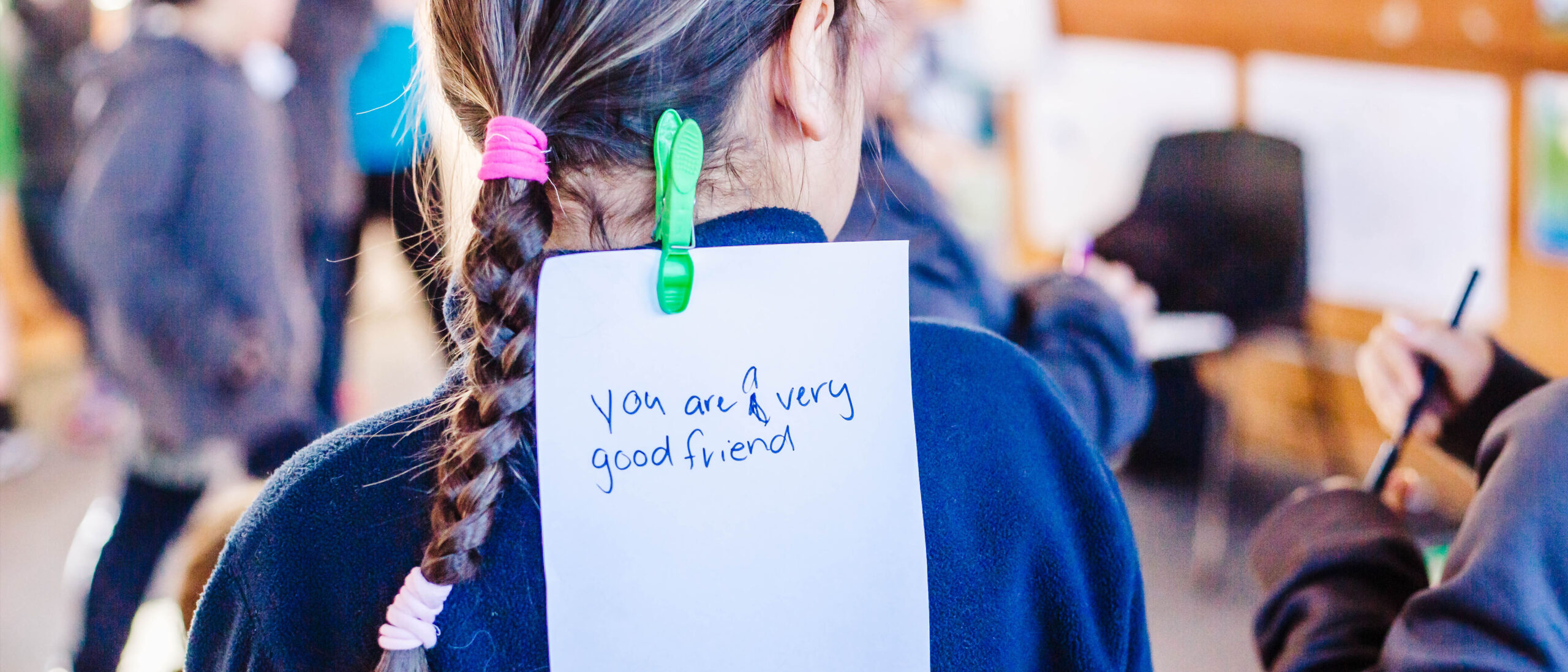 Kiwi Can student with positive words on back