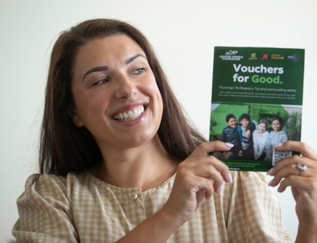Charlotte holding Vouchers for Good booklet