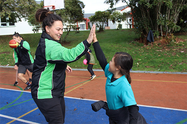 Kiwi Can Leader and student high fiving